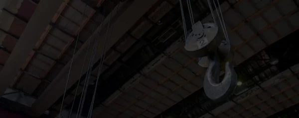Overhead crane lifting hook used in industrial facility for heavy equipment safety and EHS compliance