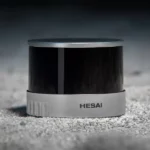 Hesai XT32 32-channel LiDAR sensor on gravel surface demonstrating rugged construction and outdoor reliability for harsh environment applications