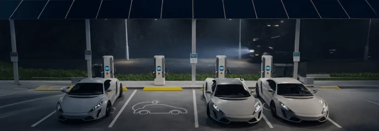 Electric vehicles charging at modern EV charging stations during nighttime with illuminated charging ports